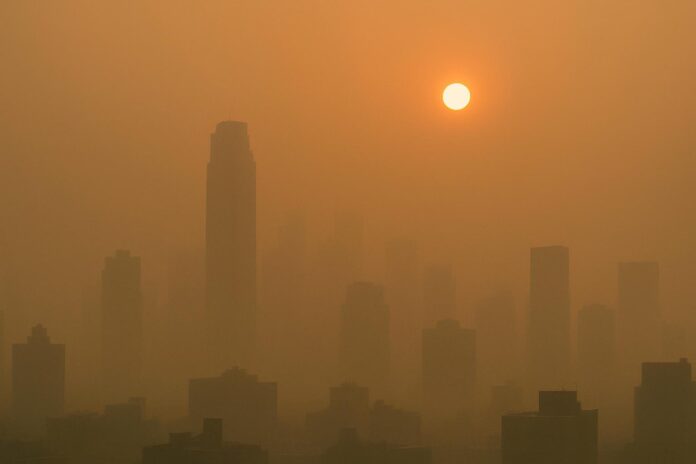 2026-07-22-ehn-how-wildfire-smoke-travels-from-ontario-to-new-york-city-and 산불 연기로 주황빛 하늘 아래 흐릿해진 대도시 스카이라인