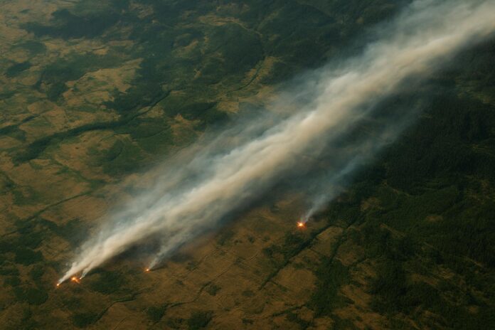 2026-08-04-earthobservatory-smoke-streams-across-eastern-washington 동부 워싱턴 상공에서 산불 연기가 길게 확산되는 모습을 위성 시점으로 표현한 이미지